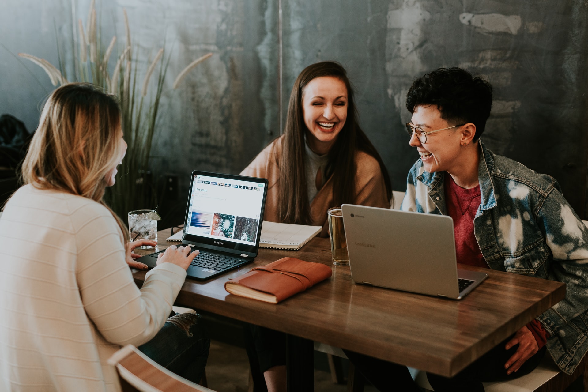 3 People Sitting at a Table with Laptops